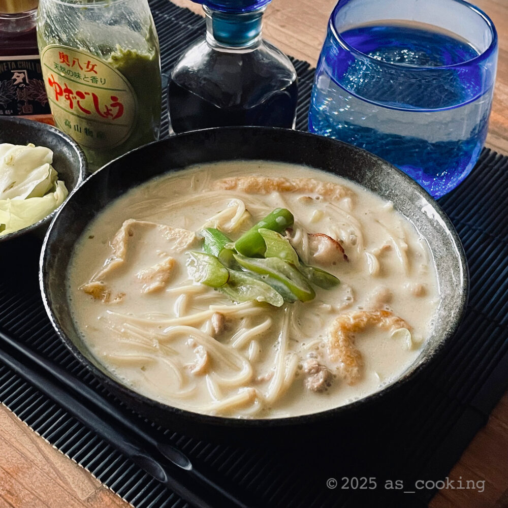 豚肉と油揚げが入った豆乳ベースのうーめんの盛り付け写真。