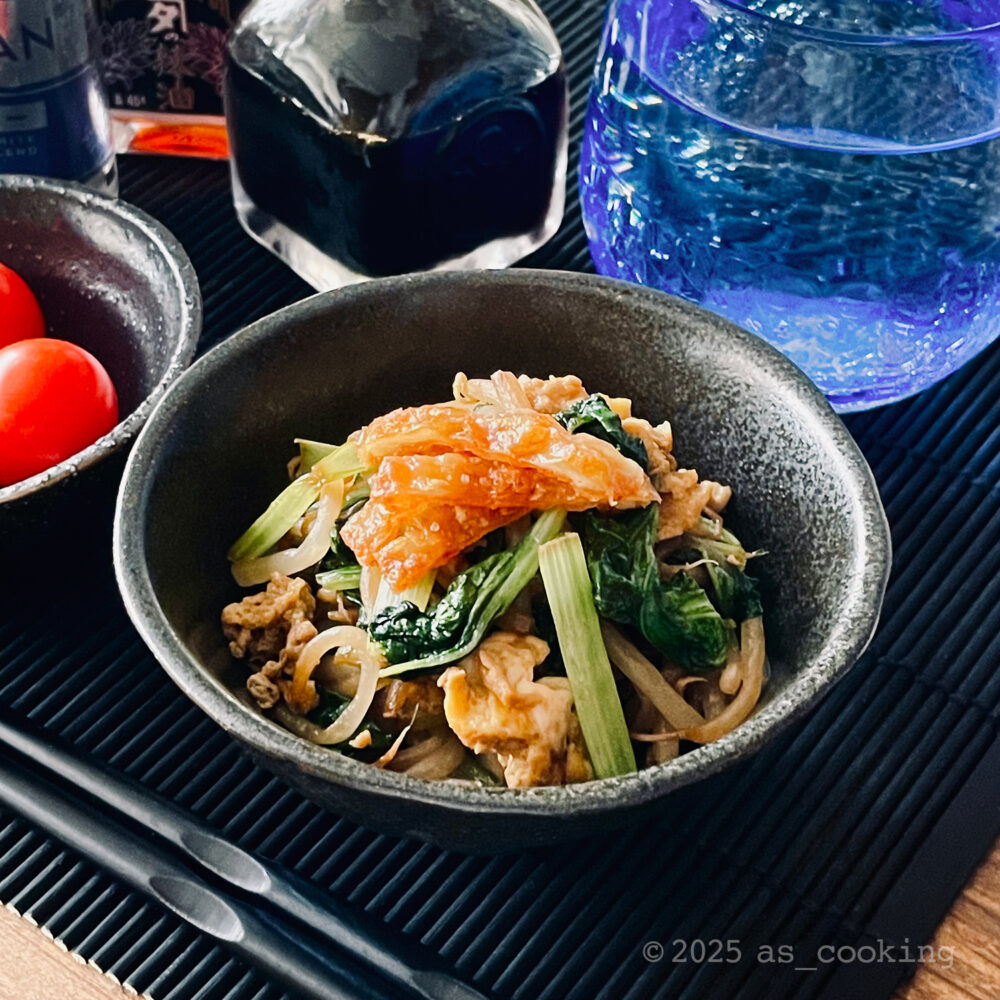 鶏油で小松菜・もやし・卵を炒め煮にし、カリカリ鶏皮をのせた一皿の写真。