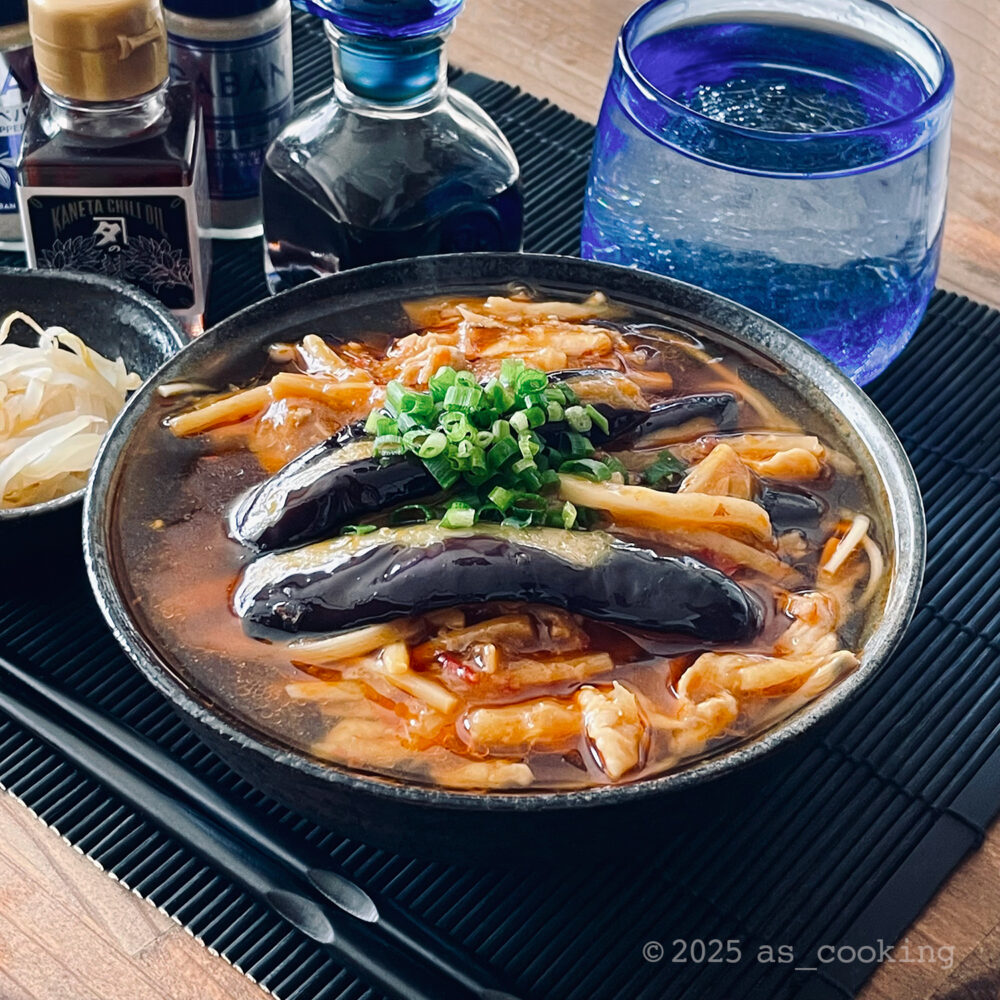 素揚げしたナスや豚肉、タケノコを甘辛い餡に絡めた、なすソバの盛り付け写真。