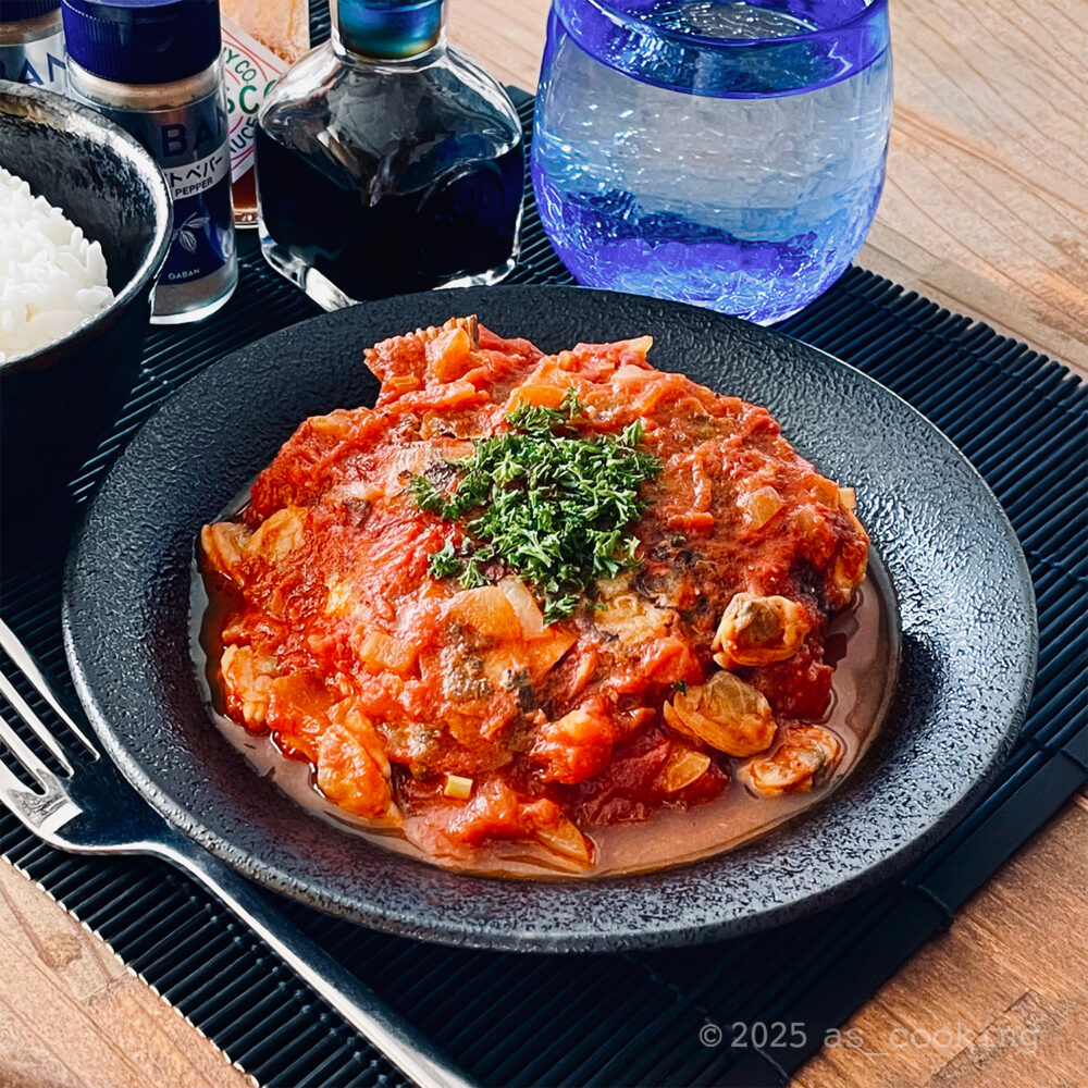 鯛のあらを使ったトマト煮込みの盛り付け写真。トマトソースに鯛の身がたっぷり入った料理。