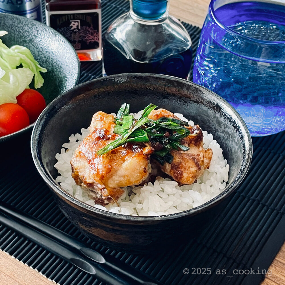 カリッとした鶏唐揚げと香りの良いニラだれがのった丼のアップ写真。