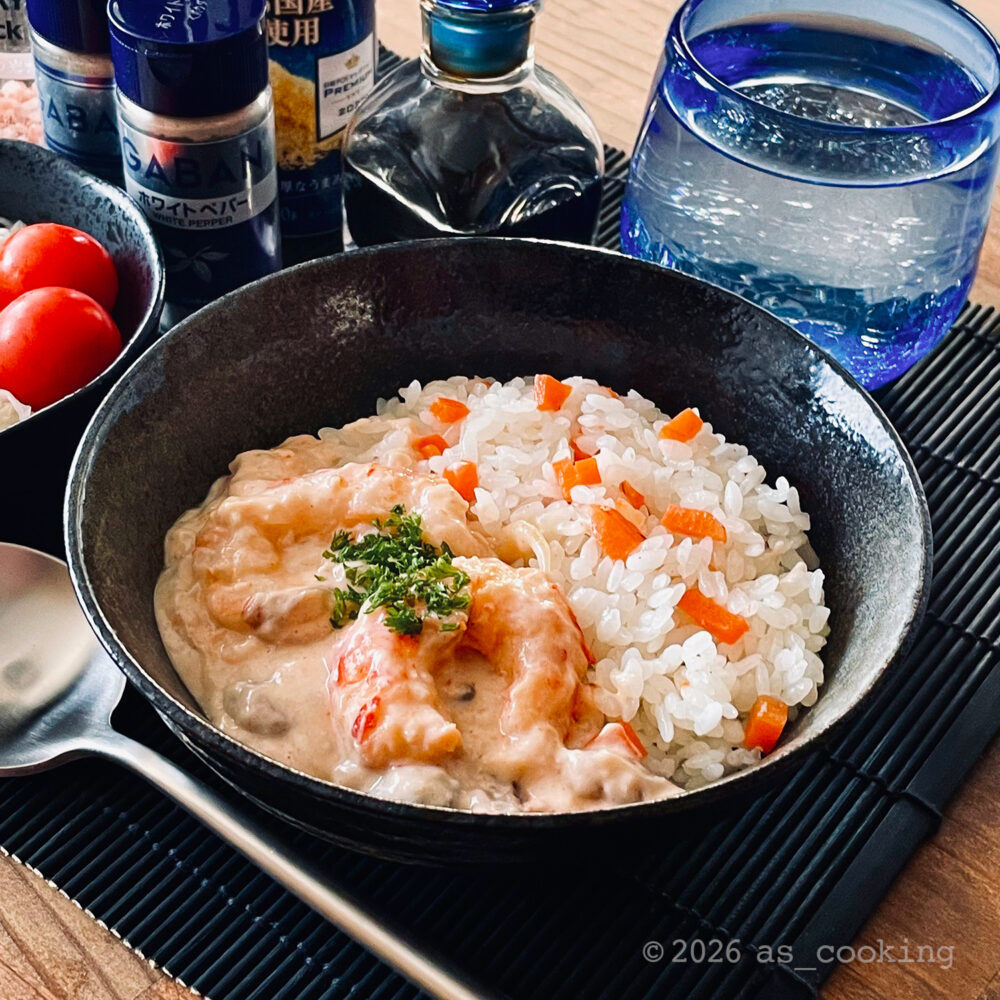 有頭えびを使って作ったえびクリームライスを皿に盛り付けた料理写真
