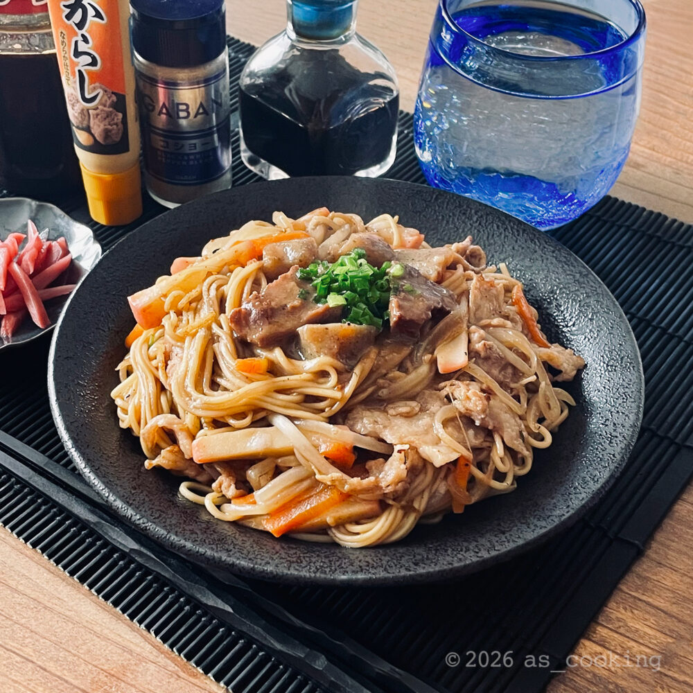 どて焼きの汁と刻みネギがかかった、具だくさんの焼きラーメン