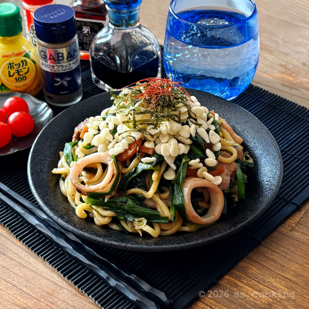 揚げ玉、刻み海苔、糸切り唐辛子をのせた具だくさんのニラ塩焼きそば