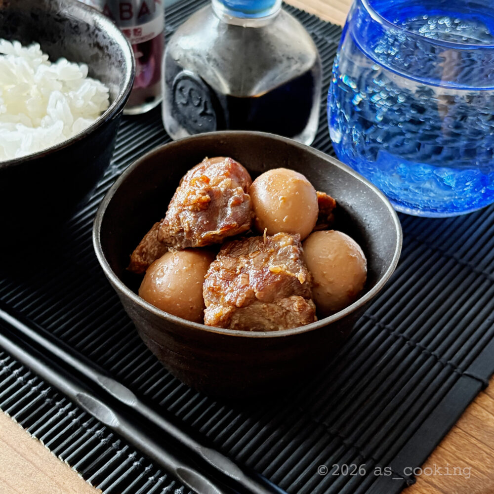 器に美しく盛り付けられた、味がよく染みたうずらの卵と小さめ角切りの豚肉の角煮