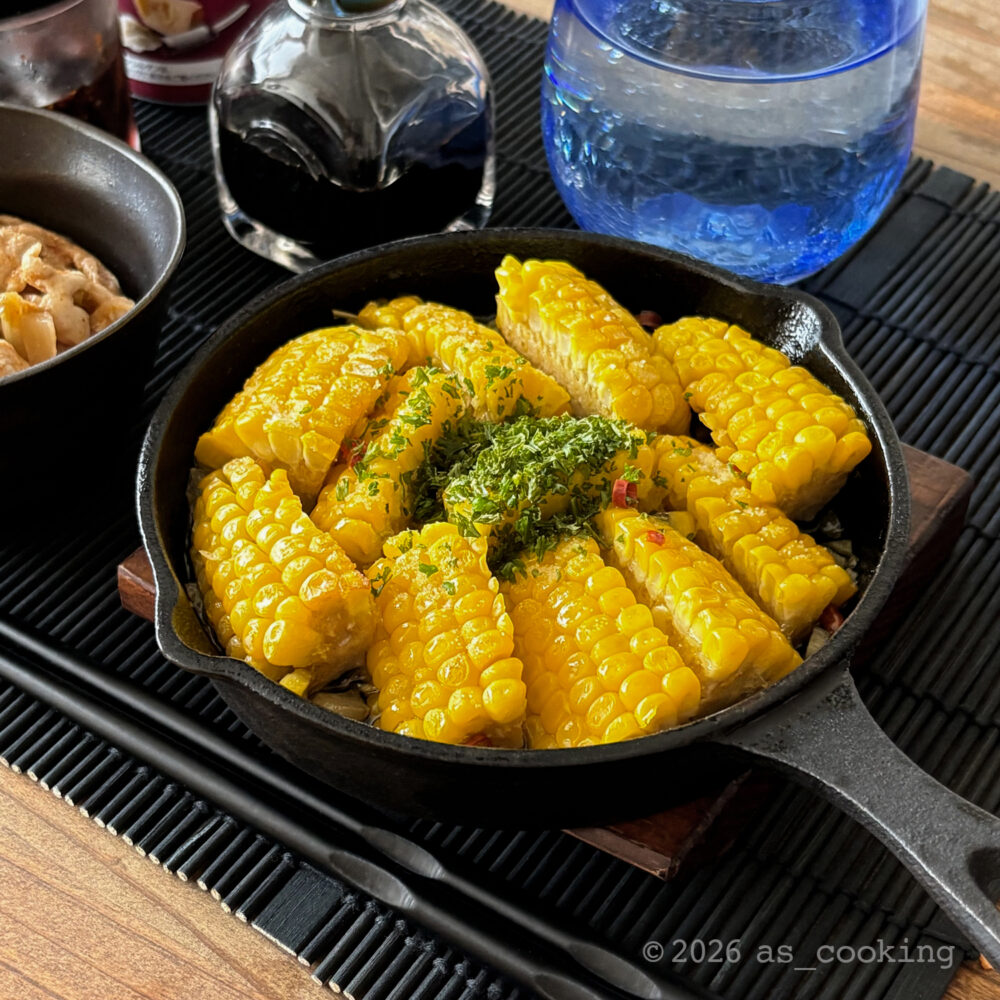 スキレットにとうもろこしを敷き詰め、ニンニクや唐辛子を加えてグツグツ煮込んだとうもろこしのアヒージョ