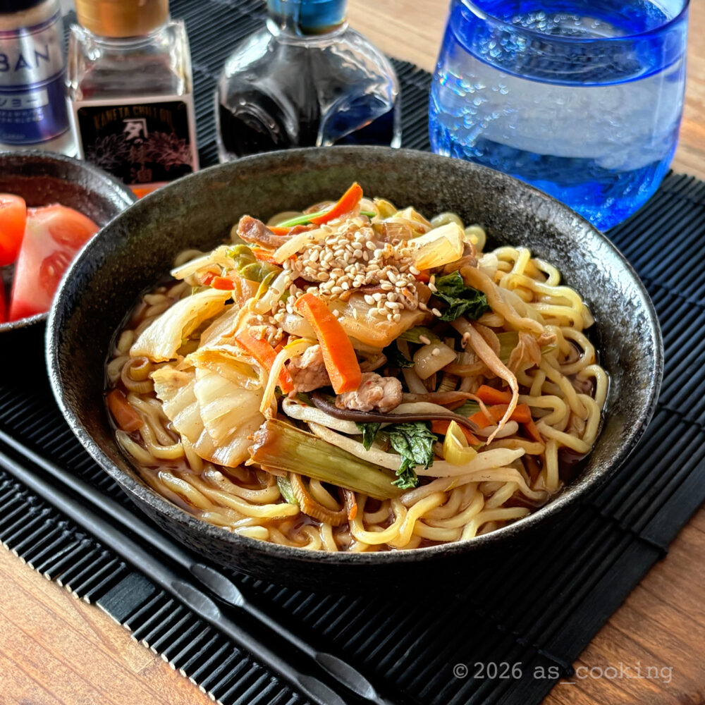 器に炒めた具材と白ゴマが盛り付けられた完成したキムチラーメン