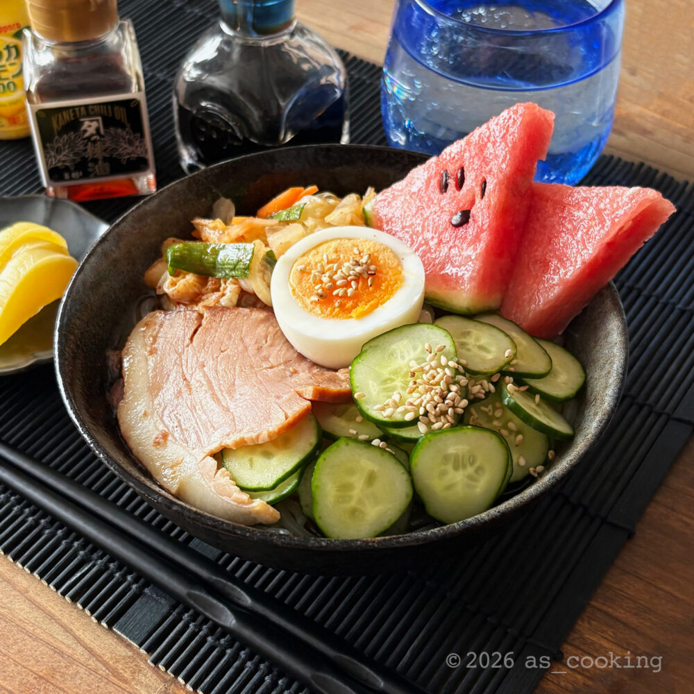 器に冷え冷えのスイカや自家製キムチ、焼豚が盛り付けられた完成した盛岡冷麺