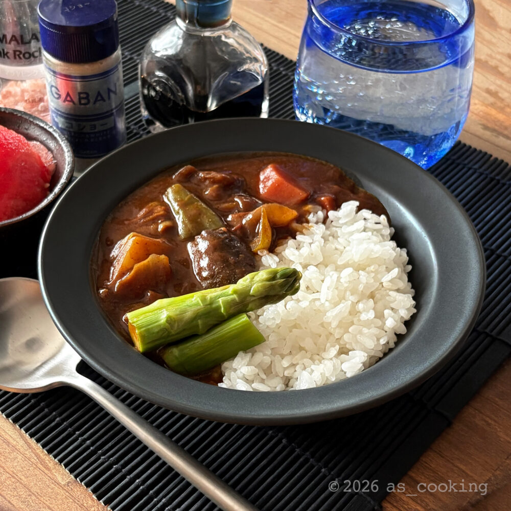 お皿にきれいに盛り付けられたアスパラガスがのった具だくさん夏野菜のカレー