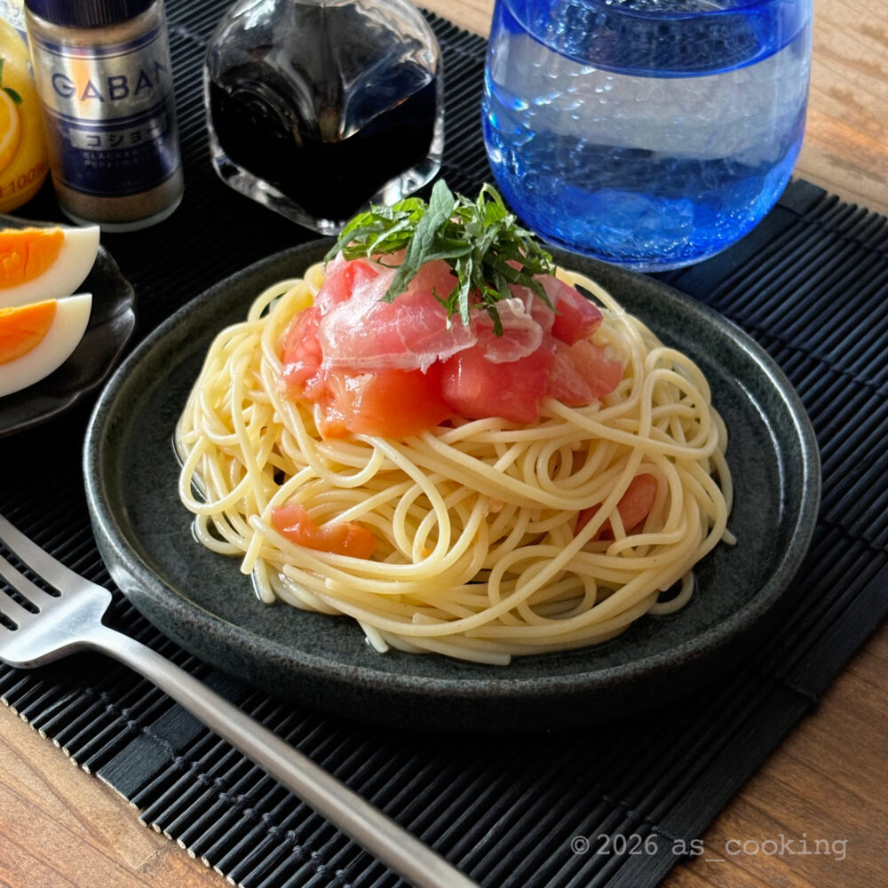 お皿に綺麗に盛り付けられ生ハムや青じそがのったスイカとトマトの冷製パスタ