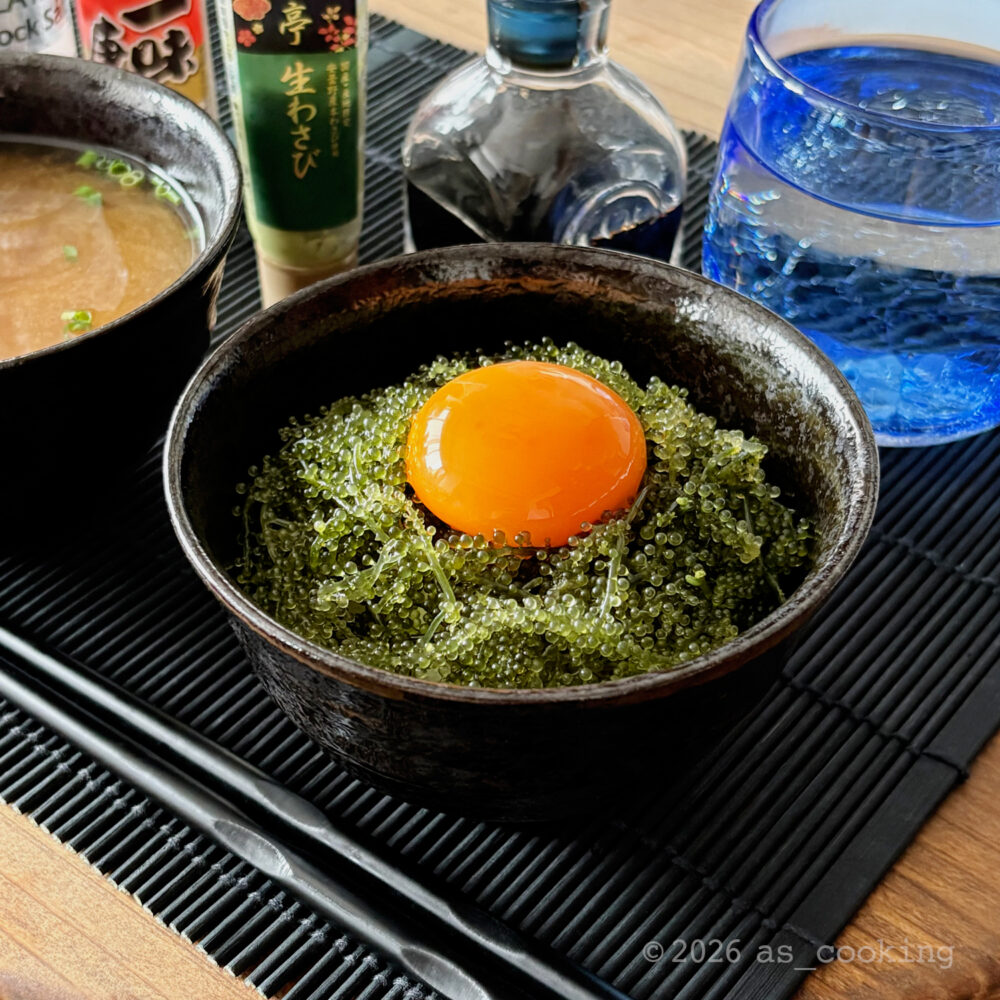 温かいご飯の上にたっぷりの海ぶどうと卵黄をのせ、わさび醤油をかけた海ぶどう丼