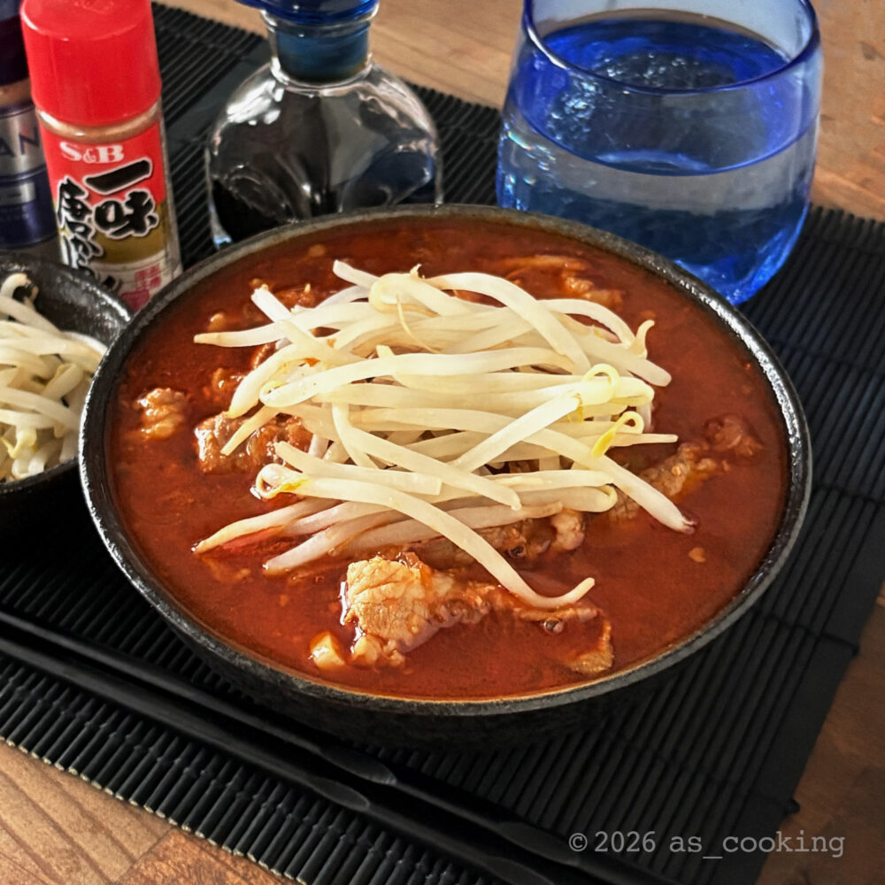 太麺の上に濃厚で赤い激辛スープを注ぎ、豚肉、炒めた長ネギ、茹でもやしをトッピングしたジェネリック北極ラーメン