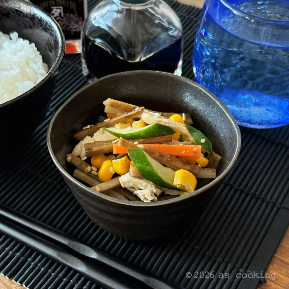 茹でたごぼうとニンジン、鶏胸肉、キュウリ、コーンを和えて器に盛り付けたごぼうサラダ