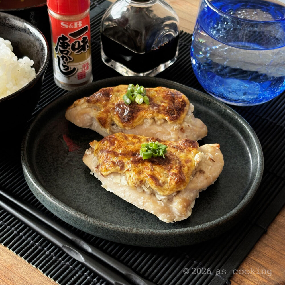 塩麹で下味をつけた鶏胸肉に玉ねぎと梅マヨをのせてオーブンで焼き、彩りに刻みネギを添えた鶏肉の梅マヨ焼き