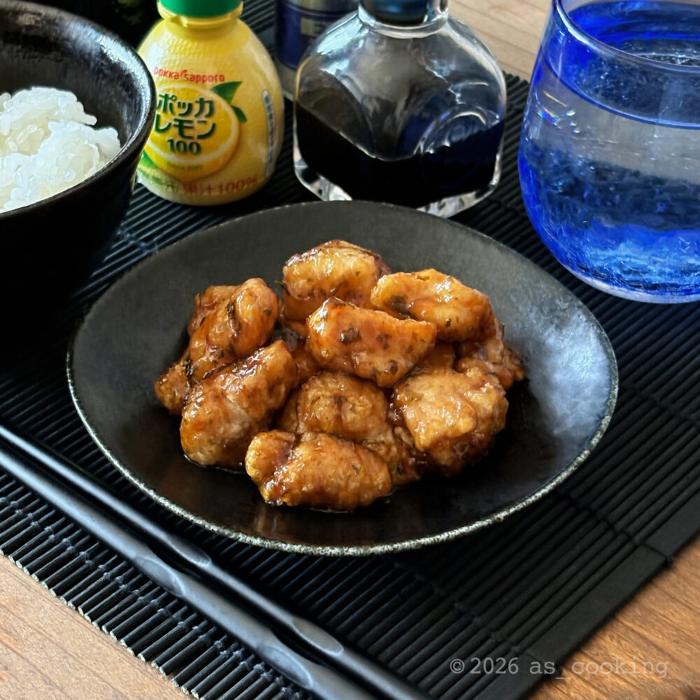カリッと揚げた一口サイズの鶏肉に爽やかなレモンダレとパセリを絡めて皿に盛り付けた鶏肉のレモン煮